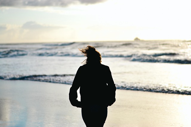 Frau am Meer im Herbst kalt Frau steht am Meer